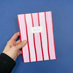 red and pink striped notebook