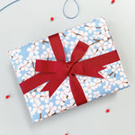 cherry blossom wrapping paper with a maroon ribbon bow