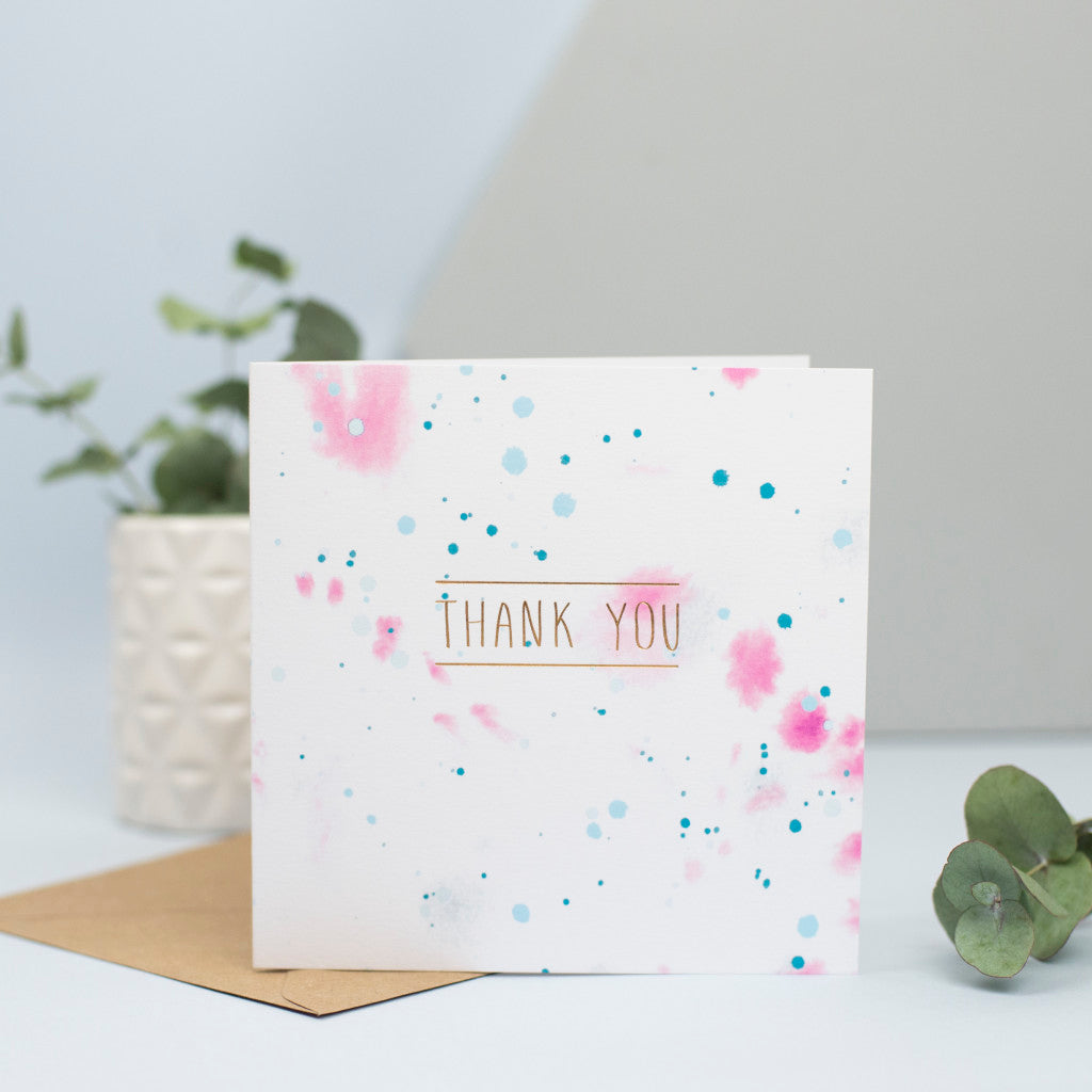 A watercolour thank you card with the words in gold foil.