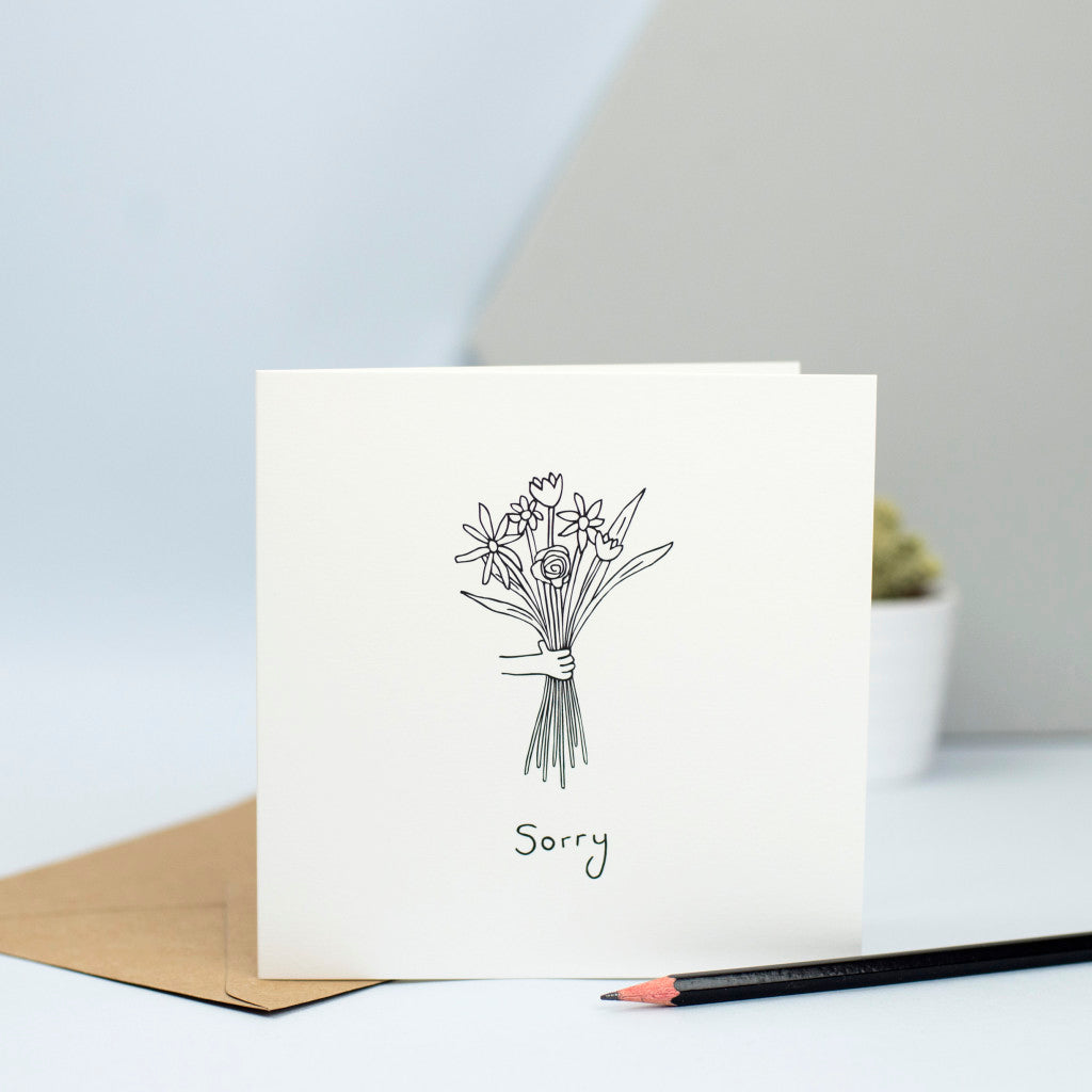 A sympathy card with a hand holding a bunch of flowers.