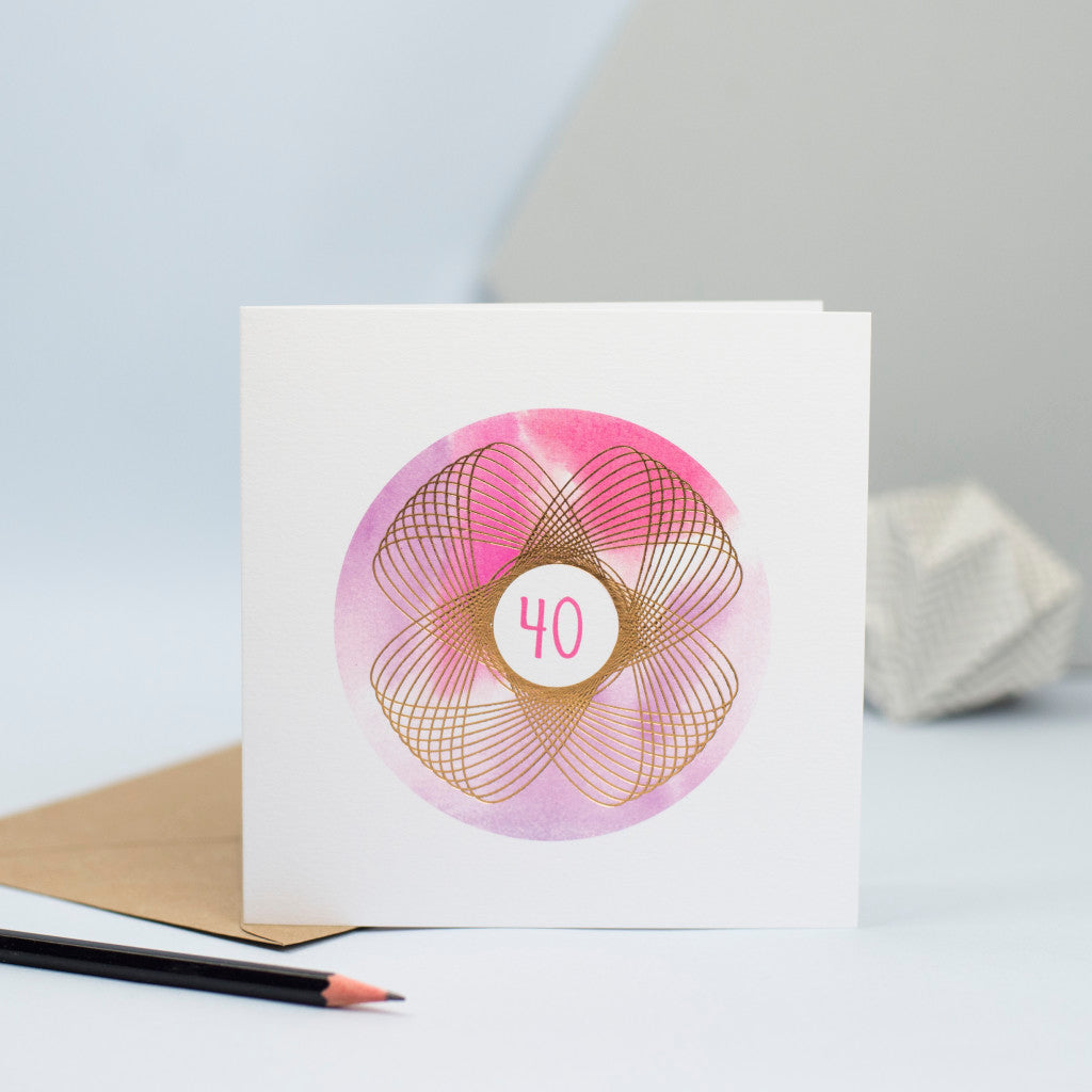 A beautiful 40th birthday card with a pink and purple watercolour background and a foiled spirograph on top.