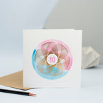 a pink and blue 80th birthday card with a gold foil spirograph