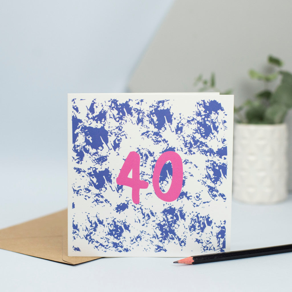 A 40th design created through mark making, with a blue textured background and a pink 40 in the foreground.