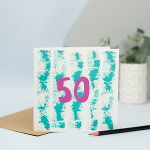 A 50th design created through mark making, with a green textured background and a pink 50 in the foreground.