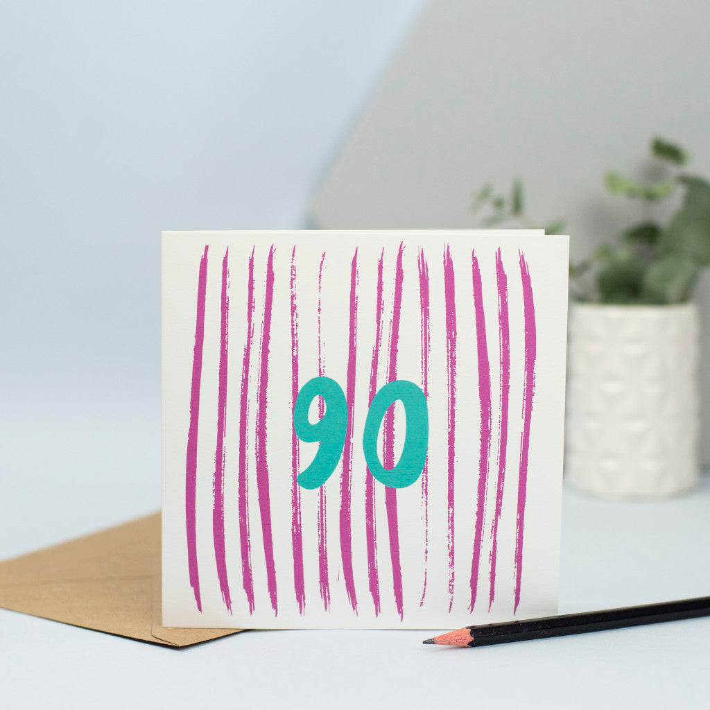 A 90th design created through mark making, with pink vertical textured stripes in the background and a green 90 in the foreground.