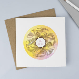 Copper foiled Spirograph with a pink & yellow watercolour background and a pink hand drawn font.