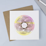Copper foiled Spirograph with a watercolour background and hand drawn font saying happy birthday in pink