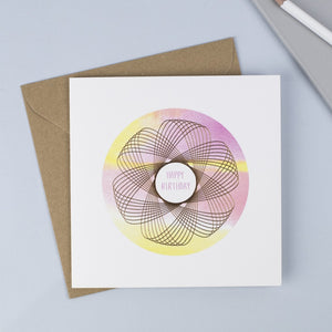 Copper foiled Spirograph with a watercolour background and hand drawn font saying happy birthday in pink