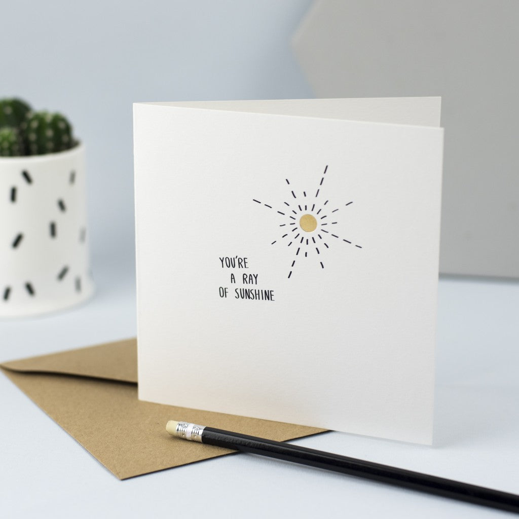 Hand drawn illustration of a sun with gold foil and the words "You're a ray of sunshine"