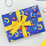 party shapes wrapping paper with a yellow ribbon bow