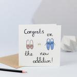 A new baby card with an illustration of three pairs of shoes.