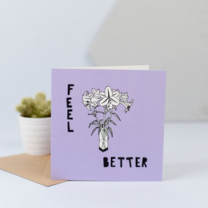 A card with some flowers and the words 'feel better'.