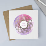 Copper foiled Spirograph with a pink and purple watercolour background and hand drawn font