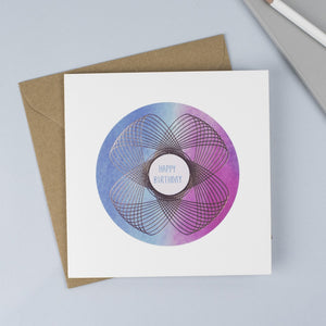 A beautiful foiled Spirograph with a blue and pink watercolour background and a hand drawn font.
