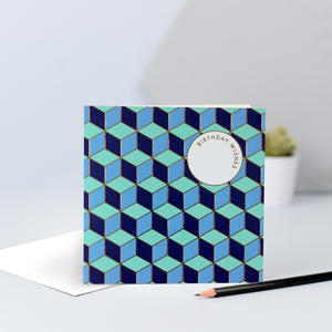 A bold tessellating pattern with blues and greens, finished with gold foil and the words "Birthday Wishes".
