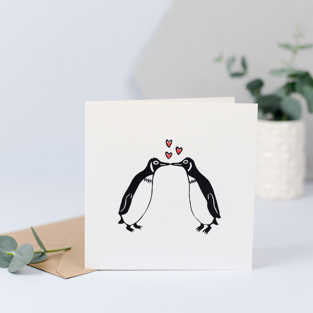 A gorgeous card with an illustration of two penguins having a kiss
