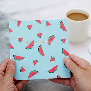 hands holding gold foiled watermelon birthday card